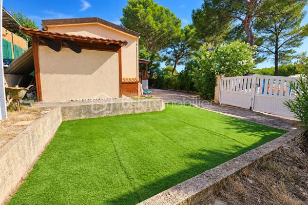 Au Camp du Castellet, dans une résidence sécurisée, Eden Park, découvrez cette habitation soigneusement réaménagée et particulièrement bien entretenue, offrant un cadre de vie agréable, calme et verdoyant.

L’intérieur propose une pièce de vie lumineuse, prolongée par une cuisine fonctionnelle et équipée, avec un accès direct vers les extérieurs.

La partie nuit se compose de deux chambrettes, dont l’une peut également être utilisée comme bureau ou chambre d’appoint selon les besoins.

Une salle d’eau rénovée avec douche et sèche-serviettes, ainsi qu’un WC indépendant, complètent l’ensemble.

À l’extérieur, la terrasse couverte d’environ 11 m², orientée sud-ouest, constitue un véritable prolongement de la pièce de vie. Elle offre un espace particulièrement agréable pour les repas et les moments de détente, tout en profitant pleinement de l’environnement extérieur.

La parcelle est plate, aménagée et facile d’entretien, avec différents espaces permettant de profiter agréablement des beaux jours.

Le bien dispose également de plusieurs solutions de rangement : un abri de jardin, un cabanon actuellement aménagé en buanderie, ainsi qu’un espace supplémentaire sous la terrasse.

Autre véritable atout : quatre possibilités de stationnement privatif, avec trois emplacements à l’extérieur et un emplacement supplémentaire à l’intérieur de la propriété.

L’habitation a bénéficié de nombreux travaux et améliorations, notamment climatisation réversible, double vitrage, volets roulants, parquet avec isolation thermique, salle d’eau et WC rénovés, chauffe-eau, ainsi qu’un escalier extérieur en bois sécurisé par une rambarde.

Côté performances énergétiques, le bien bénéficie d’un DPE classé C et d’émissions de gaz à effet de serre classées A.

La résidence Eden Park offre un environnement convivial et agréable, avec en saison estivale une piscine collective surveillée, un espace de restauration, ainsi qu’un terrain de pétanque et une aire de jeux sécurisée pour les enfants. Un arrêt de bus scolaire est situé à proximité immédiate.

L’emplacement permet enfin de profiter du cadre naturel du Castellet tout en restant proche du circuit Paul Ricard et du littoral : Saint-Cyr-sur-Mer, Bandol, Sanary-sur-Mer, La Ciotat ou encore Cassis.

Un bien fonctionnel, soigneusement entretenu, offrant de beaux espaces extérieurs, de nombreux rangements et quatre stationnements privatifs.