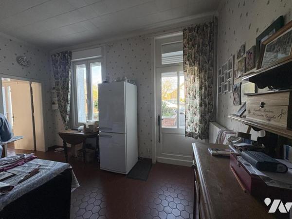 Une maison de ville semi-individuelle avec cellule commerciale, garage et jardin