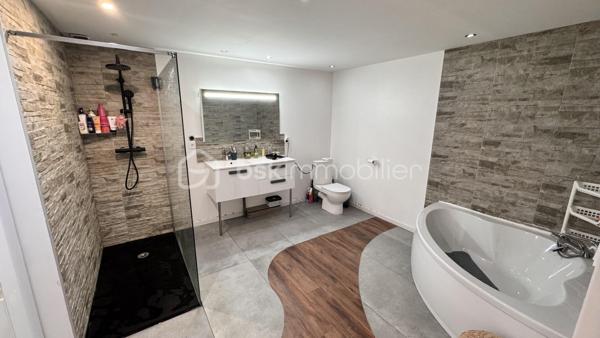 Laissez-vous séduire par cette magnifique maison de ville d'environ 300 m² habitables, un bien rare sur le marché où chaque espace a été pensé pour offrir confort, convivialité et fonctionnalité. Derrière sa façade discrète se cache une demeure familiale aux volumes impressionnants, idéale pour accueillir une grande famille, exercer une activité professionnelle ou simplement profiter d'un cadre de vie privilégié.

Dès l'entrée, le regard est immédiatement attiré par une spectaculaire pièce de vie traversante de 110 m², véritable pièce maîtresse de la maison. Cet espace baigné de lumière naturelle réunit avec élégance une cuisine dinatoire, un vaste séjour et un salon détente sublimé par une cheminée, créant une atmosphère chaleureuse où il fait bon vivre en toute saison. Les volumes généreux permettent de recevoir en toute convivialité tout en conservant des espaces de vie confortables au quotidien.

Attenants à cette pièce de vie, une buanderie et un cellier apportent un véritable confort d'organisation. Vous profiterez également d'un garage de 35 m² avec porte motorisée ainsi que d'un impressionnant garage de 126 m² avec vitrine sur rue. Ce dernier constitue un atout exceptionnel : idéal pour un artisan, une profession libérale, un collectionneur de véhicules, un espace de stockage, un atelier ou encore pour développer une activité professionnelle directement à domicile.

À l'étage, un vaste palier de 35 m², facilement aménageable en bibliothèque, salon de lecture ou espace bureau, distribue harmonieusement les différentes pièces et donne accès à 80 m² de combles aménageables, laissant entrevoir de nombreuses possibilités d'agrandissement ou d'aménagement selon vos envies.

L'espace nuit a été conçu pour répondre aux besoins de toute la famille. Il comprend :

un WC indépendant ;
une salle de bains de 6,90 m² équipée d'une douche à l'italienne, d'une baignoire d'angle et d'un meuble vasque ;
trois chambres spacieuses de 16,88 m², 17,76 m² et 17,96 m², toutes offrant de beaux volumes ;
un espace de 15 m², idéal pour une salle de jeux, un bureau, une salle de sport ou un coin télévision ;
une superbe suite parentale, véritable espace privé, composée d'une chambre de 18,15 m², d'un dressing de 17,91 m² et d'une élégante salle d'eau de 14,10 m² avec double vasque, douche à l'italienne et baignoire d'angle ;
une mezzanine de 8 m², parfaite pour un espace lecture ou télétravail.

À l'extérieur, tout est réuni pour profiter pleinement des beaux jours. Une terrasse couverte de 48 m² prolonge naturellement les espaces de vie et invite à partager de chaleureux repas en famille ou entre amis. Elle est complétée par une terrasse ouverte de 18 m², offrant un agréable espace de détente face au jardin.

Le tout s'ouvre sur un terrain clos de 1 040 m², véritable écrin de verdure où chacun pourra imaginer son projet : piscine, cuisine d'été, jardin paysager, potager, espace de jeux pour les enfants ou encore coin détente. Les possibilités sont nombreuses pour créer un extérieur à votre image.

Cette propriété se distingue par son équilibre parfait entre volumes, confort et potentiel d'évolution. Son agencement, ses nombreuses dépendances et ses espaces modulables en font un bien capable de s'adapter à tous les projets de vie, qu'ils soient familiaux ou professionnels.

Les atouts de cette propriété
Environ 300 m² habitables.
Pièce de vie traversante de 110 m² avec cheminée.
Cuisine dinatoire ouverte sur les espaces de réception.
4 grandes chambres, dont une suite parentale avec dressing et salle d'eau privative.
Salle de bains familiale avec douche à l'italienne et baignoire d'angle.
Espace bureau ou salle de jeux de 15 m².
Vaste palier de 35 m².
80 m² de combles aménageables.
Buanderie et cellier.
Deux garages de 35 m² et 126 m², dont un avec vitrine sur rue, idéal pour une activité professionnelle.
Terrasse couverte de 48 m² et terrasse ouverte de 18 m².
Terrain clos de 1 040 m² offrant de multiples possibilités d'aménagement.
À proximité immédiate des commerces, des écoles et de toutes les commodités.

Une propriété unique sur le secteur de Blaye-les-Mines, où les volumes, les prestations et le potentiel se conjuguent pour offrir un cadre de vie exceptionnel. Que vous recherchiez une grande maison familiale, un lieu permettant d'allier vie privée et activité professionnelle ou un bien aux possibilités d'évolution remarquables, cette demeure répondra à toutes vos attentes. Une visite s'impose pour découvrir tout son charme et son incroyable potentiel.