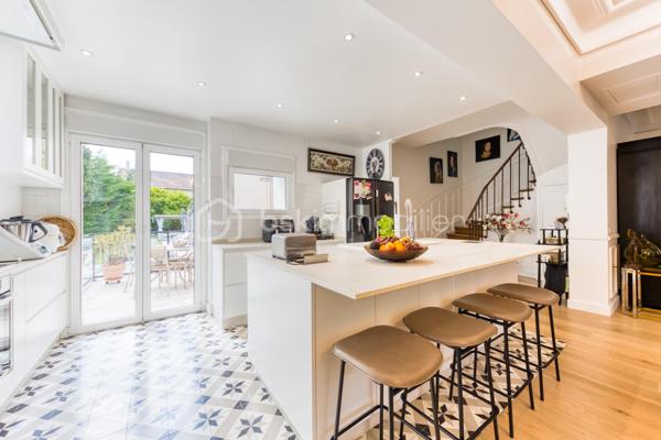Découvrez cette superbe maison familiale aux prestations haut de gamme, pensée pour offrir confort, volumes et luminosité dans un environnement privilégié. Mitoyenne d’un seul côté, cette propriété séduit dès l’arrivée avec son portail coulissant et son vaste espace de stationnement pouvant accueillir jusqu’à trois véhicules.
À l’extérieur, tout a été imaginé pour profiter pleinement des beaux jours : agréable espace repas, coin détente, jardin soigneusement aménagé, piscine chauffée avec volet électrique, jacuzzi, ainsi qu’une généreuse terrasse permettant de recevoir famille et amis dans un cadre intimiste et ensoleillé. Exposé plein sud, le jardin bénéficie d’une luminosité exceptionnelle tout au long de la journée.
Quelques marches mènent à l’entrée de la maison, où vous découvrirez une magnifique pièce de vie baignée de lumière composée d’un salon séjour chaleureux et d’une cuisine ouverte moderne, entièrement équipée et aménagée. Son design épuré aux tons clairs permet de s’y projeter immédiatement. Une terrasse attenante offre un espace idéal pour profiter d’un café au soleil dès le matin.
Quelques marches plus bas, un second salon aux volumes impressionnants vient compléter les espaces de réception. Celui-ci s’ouvre sur une superbe véranda aménagée en cuisine d’été, entièrement équipée de baies vitrées accordéon permettant une ouverture totale sur le jardin et la piscine. Un véritable espace de vie dedans/dehors à l’esprit vacances et convivialité.
La maison dispose également d’un sous-sol total offrant de nombreuses possibilités d’aménagement : salle de sport, espace télétravail, atelier, buanderie, salle de jeux, cave ou stockage.
L’espace nuit est réparti sur deux étages desservis par un élégant escalier en colimaçon en bois.
Au premier étage, vous trouverez une première suite parentale avec terrasse privative, vue dégagée sur le jardin et la piscine, ainsi que sa salle de bain attenante. Une seconde très grande chambre, actuellement aménagée avec un vaste dressing, résulte de la réunion de deux chambres et peut facilement être redivisée afin de créer une chambre supplémentaire. Ce niveau comprend également une salle de bain familiale avec baignoire, double vasque et double douche communicante, ainsi qu’un WC indépendant.
Au dernier étage, les combles aménagés accueillent un superbe espace composé actuellement de deux pièces reliées, idéal pour un adolescent, une suite indépendante ou un espace salon/chambre. Cet étage dispose également de sa propre salle d’eau avec WC. Là encore, les volumes permettent facilement d’envisager une redistribution des espaces.
Aujourd’hui configurée avec 3 chambres, cette maison offre un fort potentiel d’aménagement et peut facilement être repensée pour accueillir jusqu’à 5 chambres selon les besoins.
Une propriété rare, aux volumes généreux et aux prestations de qualité, idéale pour une famille recherchant confort, modernité et espaces de vie exceptionnels.