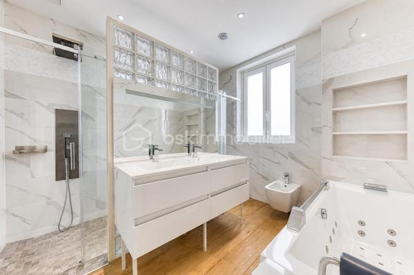 Découvrez cette superbe maison familiale aux prestations haut de gamme, pensée pour offrir confort, volumes et luminosité dans un environnement privilégié. Mitoyenne d’un seul côté, cette propriété séduit dès l’arrivée avec son portail coulissant et son vaste espace de stationnement pouvant accueillir jusqu’à trois véhicules.
À l’extérieur, tout a été imaginé pour profiter pleinement des beaux jours : agréable espace repas, coin détente, jardin soigneusement aménagé, piscine chauffée avec volet électrique, jacuzzi, ainsi qu’une généreuse terrasse permettant de recevoir famille et amis dans un cadre intimiste et ensoleillé. Exposé plein sud, le jardin bénéficie d’une luminosité exceptionnelle tout au long de la journée.
Quelques marches mènent à l’entrée de la maison, où vous découvrirez une magnifique pièce de vie baignée de lumière composée d’un salon séjour chaleureux et d’une cuisine ouverte moderne, entièrement équipée et aménagée. Son design épuré aux tons clairs permet de s’y projeter immédiatement. Une terrasse attenante offre un espace idéal pour profiter d’un café au soleil dès le matin.
Quelques marches plus bas, un second salon aux volumes impressionnants vient compléter les espaces de réception. Celui-ci s’ouvre sur une superbe véranda aménagée en cuisine d’été, entièrement équipée de baies vitrées accordéon permettant une ouverture totale sur le jardin et la piscine. Un véritable espace de vie dedans/dehors à l’esprit vacances et convivialité.
La maison dispose également d’un sous-sol total offrant de nombreuses possibilités d’aménagement : salle de sport, espace télétravail, atelier, buanderie, salle de jeux, cave ou stockage.
L’espace nuit est réparti sur deux étages desservis par un élégant escalier en colimaçon en bois.
Au premier étage, vous trouverez une première suite parentale avec terrasse privative, vue dégagée sur le jardin et la piscine, ainsi que sa salle de bain attenante. Une seconde très grande chambre, actuellement aménagée avec un vaste dressing, résulte de la réunion de deux chambres et peut facilement être redivisée afin de créer une chambre supplémentaire. Ce niveau comprend également une salle de bain familiale avec baignoire, double vasque et double douche communicante, ainsi qu’un WC indépendant.
Au dernier étage, les combles aménagés accueillent un superbe espace composé actuellement de deux pièces reliées, idéal pour un adolescent, une suite indépendante ou un espace salon/chambre. Cet étage dispose également de sa propre salle d’eau avec WC. Là encore, les volumes permettent facilement d’envisager une redistribution des espaces.
Aujourd’hui configurée avec 3 chambres, cette maison offre un fort potentiel d’aménagement et peut facilement être repensée pour accueillir jusqu’à 5 chambres selon les besoins.
Une propriété rare, aux volumes généreux et aux prestations de qualité, idéale pour une famille recherchant confort, modernité et espaces de vie exceptionnels.