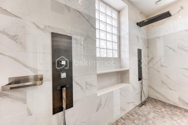 Découvrez cette superbe maison familiale aux prestations haut de gamme, pensée pour offrir confort, volumes et luminosité dans un environnement privilégié. Mitoyenne d’un seul côté, cette propriété séduit dès l’arrivée avec son portail coulissant et son vaste espace de stationnement pouvant accueillir jusqu’à trois véhicules.
À l’extérieur, tout a été imaginé pour profiter pleinement des beaux jours : agréable espace repas, coin détente, jardin soigneusement aménagé, piscine chauffée avec volet électrique, jacuzzi, ainsi qu’une généreuse terrasse permettant de recevoir famille et amis dans un cadre intimiste et ensoleillé. Exposé plein sud, le jardin bénéficie d’une luminosité exceptionnelle tout au long de la journée.
Quelques marches mènent à l’entrée de la maison, où vous découvrirez une magnifique pièce de vie baignée de lumière composée d’un salon séjour chaleureux et d’une cuisine ouverte moderne, entièrement équipée et aménagée. Son design épuré aux tons clairs permet de s’y projeter immédiatement. Une terrasse attenante offre un espace idéal pour profiter d’un café au soleil dès le matin.
Quelques marches plus bas, un second salon aux volumes impressionnants vient compléter les espaces de réception. Celui-ci s’ouvre sur une superbe véranda aménagée en cuisine d’été, entièrement équipée de baies vitrées accordéon permettant une ouverture totale sur le jardin et la piscine. Un véritable espace de vie dedans/dehors à l’esprit vacances et convivialité.
La maison dispose également d’un sous-sol total offrant de nombreuses possibilités d’aménagement : salle de sport, espace télétravail, atelier, buanderie, salle de jeux, cave ou stockage.
L’espace nuit est réparti sur deux étages desservis par un élégant escalier en colimaçon en bois.
Au premier étage, vous trouverez une première suite parentale avec terrasse privative, vue dégagée sur le jardin et la piscine, ainsi que sa salle de bain attenante. Une seconde très grande chambre, actuellement aménagée avec un vaste dressing, résulte de la réunion de deux chambres et peut facilement être redivisée afin de créer une chambre supplémentaire. Ce niveau comprend également une salle de bain familiale avec baignoire, double vasque et double douche communicante, ainsi qu’un WC indépendant.
Au dernier étage, les combles aménagés accueillent un superbe espace composé actuellement de deux pièces reliées, idéal pour un adolescent, une suite indépendante ou un espace salon/chambre. Cet étage dispose également de sa propre salle d’eau avec WC. Là encore, les volumes permettent facilement d’envisager une redistribution des espaces.
Aujourd’hui configurée avec 3 chambres, cette maison offre un fort potentiel d’aménagement et peut facilement être repensée pour accueillir jusqu’à 5 chambres selon les besoins.
Une propriété rare, aux volumes généreux et aux prestations de qualité, idéale pour une famille recherchant confort, modernité et espaces de vie exceptionnels.