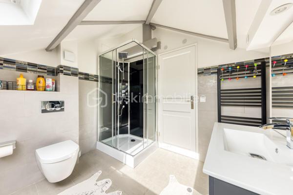 Découvrez cette superbe maison familiale aux prestations haut de gamme, pensée pour offrir confort, volumes et luminosité dans un environnement privilégié. Mitoyenne d’un seul côté, cette propriété séduit dès l’arrivée avec son portail coulissant et son vaste espace de stationnement pouvant accueillir jusqu’à trois véhicules.
À l’extérieur, tout a été imaginé pour profiter pleinement des beaux jours : agréable espace repas, coin détente, jardin soigneusement aménagé, piscine chauffée avec volet électrique, jacuzzi, ainsi qu’une généreuse terrasse permettant de recevoir famille et amis dans un cadre intimiste et ensoleillé. Exposé plein sud, le jardin bénéficie d’une luminosité exceptionnelle tout au long de la journée.
Quelques marches mènent à l’entrée de la maison, où vous découvrirez une magnifique pièce de vie baignée de lumière composée d’un salon séjour chaleureux et d’une cuisine ouverte moderne, entièrement équipée et aménagée. Son design épuré aux tons clairs permet de s’y projeter immédiatement. Une terrasse attenante offre un espace idéal pour profiter d’un café au soleil dès le matin.
Quelques marches plus bas, un second salon aux volumes impressionnants vient compléter les espaces de réception. Celui-ci s’ouvre sur une superbe véranda aménagée en cuisine d’été, entièrement équipée de baies vitrées accordéon permettant une ouverture totale sur le jardin et la piscine. Un véritable espace de vie dedans/dehors à l’esprit vacances et convivialité.
La maison dispose également d’un sous-sol total offrant de nombreuses possibilités d’aménagement : salle de sport, espace télétravail, atelier, buanderie, salle de jeux, cave ou stockage.
L’espace nuit est réparti sur deux étages desservis par un élégant escalier en colimaçon en bois.
Au premier étage, vous trouverez une première suite parentale avec terrasse privative, vue dégagée sur le jardin et la piscine, ainsi que sa salle de bain attenante. Une seconde très grande chambre, actuellement aménagée avec un vaste dressing, résulte de la réunion de deux chambres et peut facilement être redivisée afin de créer une chambre supplémentaire. Ce niveau comprend également une salle de bain familiale avec baignoire, double vasque et double douche communicante, ainsi qu’un WC indépendant.
Au dernier étage, les combles aménagés accueillent un superbe espace composé actuellement de deux pièces reliées, idéal pour un adolescent, une suite indépendante ou un espace salon/chambre. Cet étage dispose également de sa propre salle d’eau avec WC. Là encore, les volumes permettent facilement d’envisager une redistribution des espaces.
Aujourd’hui configurée avec 3 chambres, cette maison offre un fort potentiel d’aménagement et peut facilement être repensée pour accueillir jusqu’à 5 chambres selon les besoins.
Une propriété rare, aux volumes généreux et aux prestations de qualité, idéale pour une famille recherchant confort, modernité et espaces de vie exceptionnels.