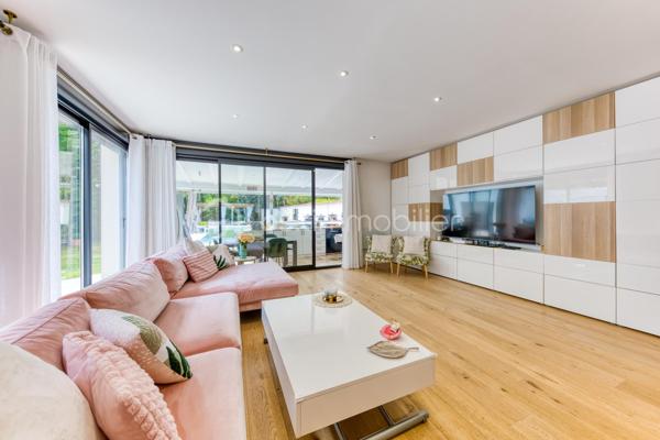 Découvrez cette superbe maison familiale aux prestations haut de gamme, pensée pour offrir confort, volumes et luminosité dans un environnement privilégié. Mitoyenne d’un seul côté, cette propriété séduit dès l’arrivée avec son portail coulissant et son vaste espace de stationnement pouvant accueillir jusqu’à trois véhicules.
À l’extérieur, tout a été imaginé pour profiter pleinement des beaux jours : agréable espace repas, coin détente, jardin soigneusement aménagé, piscine chauffée avec volet électrique, jacuzzi, ainsi qu’une généreuse terrasse permettant de recevoir famille et amis dans un cadre intimiste et ensoleillé. Exposé plein sud, le jardin bénéficie d’une luminosité exceptionnelle tout au long de la journée.
Quelques marches mènent à l’entrée de la maison, où vous découvrirez une magnifique pièce de vie baignée de lumière composée d’un salon séjour chaleureux et d’une cuisine ouverte moderne, entièrement équipée et aménagée. Son design épuré aux tons clairs permet de s’y projeter immédiatement. Une terrasse attenante offre un espace idéal pour profiter d’un café au soleil dès le matin.
Quelques marches plus bas, un second salon aux volumes impressionnants vient compléter les espaces de réception. Celui-ci s’ouvre sur une superbe véranda aménagée en cuisine d’été, entièrement équipée de baies vitrées accordéon permettant une ouverture totale sur le jardin et la piscine. Un véritable espace de vie dedans/dehors à l’esprit vacances et convivialité.
La maison dispose également d’un sous-sol total offrant de nombreuses possibilités d’aménagement : salle de sport, espace télétravail, atelier, buanderie, salle de jeux, cave ou stockage.
L’espace nuit est réparti sur deux étages desservis par un élégant escalier en colimaçon en bois.
Au premier étage, vous trouverez une première suite parentale avec terrasse privative, vue dégagée sur le jardin et la piscine, ainsi que sa salle de bain attenante. Une seconde très grande chambre, actuellement aménagée avec un vaste dressing, résulte de la réunion de deux chambres et peut facilement être redivisée afin de créer une chambre supplémentaire. Ce niveau comprend également une salle de bain familiale avec baignoire, double vasque et double douche communicante, ainsi qu’un WC indépendant.
Au dernier étage, les combles aménagés accueillent un superbe espace composé actuellement de deux pièces reliées, idéal pour un adolescent, une suite indépendante ou un espace salon/chambre. Cet étage dispose également de sa propre salle d’eau avec WC. Là encore, les volumes permettent facilement d’envisager une redistribution des espaces.
Aujourd’hui configurée avec 3 chambres, cette maison offre un fort potentiel d’aménagement et peut facilement être repensée pour accueillir jusqu’à 5 chambres selon les besoins.
Une propriété rare, aux volumes généreux et aux prestations de qualité, idéale pour une famille recherchant confort, modernité et espaces de vie exceptionnels.