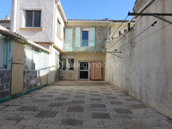 Située à Lézignan-Corbières, à proximité immédiate des commerces, écoles et services, cette maison de ville traversante d'environ 128 m² offre de beaux volumes et un fort potentiel pour accueillir une famille, pour un projet de résidence principale.

Dès l'entrée, vous découvrirez un rez-de-chaussée fonctionnel composé d'un hall avec WC indépendant ainsi qu'une agréable pièce de vie avec cuisine aménagée ouverte sur la cour, un véritable espace extérieur propice aux repas en famille et aux moments de détente. À l'étage, un palier dessert quatre chambres confortables, dont deux bénéficiant d'un accès direct au balcon, ainsi qu'un bureau ou dressing. Une salle d'eau et un second WC indépendant complètent ce niveau.

La maison est équipée de menuiseries en double vitrage et de volets roulants manuels et électriques. À l'extérieur, la cour dispose également d'espaces annexes appréciables avec un cellier, un atelier et une salle d'eau supplémentaire, offrant de nombreuses possibilités de rangement ou d'aménagement selon vos besoins.

Des travaux de rafraîchissement sont à prévoir afin de révéler tout le potentiel de ce bien et le personnaliser à votre goût.

Idéalement située dans un secteur pratique et recherché de Lézignan-Corbières, cette maison permet de profiter de toutes les commodités à pied tout en bénéficiant d'un espace de vie généreux.

Une belle opportunité à saisir. Contactez moi pour organiser une visite et découvrir tout le potentiel de cette maison.