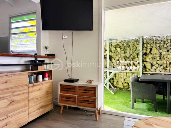 Jérôme MIGLIORE pour BSK Immobilier vous propose à la vente :

ENSEMBLE IMMOBILIER  – UN LIEU DE VIE, UN POTENTIEL PROFESSIONNEL ET UNE ACTIVITÉ TOURISTIQUE DÉJÀ RENTABLE

Entre Sainte-Anne et Le Moule – Magnifique propriété arborée de 3 000 m²

Il est des biens qui offrent bien plus qu’un simple lieu de résidence.
Cet ensemble immobilier rare, niché dans un environnement verdoyant et préservé entre Sainte-Anne et Le Moule, conjugue harmonieusement qualité de vie, indépendance, potentiel de développement et rentabilité locative.
Implantée sur un magnifique terrain arboré de 3 000 m², cette propriété  de 300 m2 de bâti environ constitue une véritable opportunité pour une famille en quête d’espace, un investisseur à la recherche de revenus complémentaires ou un professionnel souhaitant développer son activité sur place.
	
L’ensemble comprend une résidence principale, deux hébergements touristiques indépendants, un bureau, ainsi que de généreux espaces annexes dédiés au stockage, au bricolage ou à une activité professionnelle.

UNE RÉSIDENCE PRINCIPALE AUX ACCENTS TROPICAUX
Développant une surface annoncée de 215 m² habitables pour l’ensemble immobilier, dont une maison principale offrant aujourd’hui 137 m² de surface de vie, cette habitation séduit par ses volumes, son agencement et son ouverture sur l’extérieur.
Elle propose trois chambres climatisées, une mezzanine de 15 m² pouvant accueillir des couchages supplémentaires, deux salles d’eau, deux WC, ainsi qu’un séjour de 36 m² propice aux moments de convivialité.
La cuisine indépendante et aménagée complète cet espace de vie fonctionnel et agréable.
Dans le prolongement de la maison, une vaste terrasse de 57 m² invite à profiter pleinement du climat guadeloupéen, avec une perspective dégagée sur les espaces extérieurs.

UN ESPACE EXTÉRIEUR DÉDIÉ À LA DÉTENTE
Véritable invitation au farniente, l’espace piscine constitue l’un des atouts majeurs de la propriété.
Piscine au sel chauffée de 8 x 4 mètres, grand deck, bar extérieur et barbecue composent un cadre idéal pour recevoir famille et amis ou séduire une clientèle touristique en quête d’un séjour sous le soleil des Antilles.
Le terrain, richement arboré et agrémenté de nombreux citronniers, bénéficie d’une absence de vis-à-vis, garantissant intimité et tranquillité.
Les citronniers procurent actuellement un revenu complémentaire, ajoutant une dimension productive à cet environnement privilégié.

UN POTENTIEL LOCATIF DÉJÀ EN PLACE
L’un des points forts de cet ensemble réside dans la présence de deux hébergements indépendants : un studio de 36 m2 et un appartement de type T2 de 42 m2 avec son  jacuzzi et sa terrasse.
Déjà exploités dans le cadre d’une activité de location touristique, ils permettent d'envisager la poursuite d’une activité génératrice de revenus, tout en préservant l’intimité des occupants de la résidence principale.
Cette configuration se prête particulièrement à un projet de vie associant résidence familiale et activité professionnelle, avec la possibilité de développer ou d’optimiser l’exploitation selon les objectifs du futur acquéreur.
La possibilité d’une transmission de l’activité existante pourra également être étudiée.

DES DÉPENDANCES AUX MULTIPLES POSSIBILITÉS
La propriété dispose d’espaces annexes particulièrement intéressants pour les acquéreurs ayant besoin de surfaces complémentaires :
Un grand garage de 45 m².
Un atelier de 42 m².
Deux pièces de stockage non aménagées totalisant 29 m².
Un bureau indépendant, offrant un espace adapté au télétravail ou à une activité professionnelle.
Ces dépendances permettent d’envisager de nombreux usages : atelier artisanal, espace de travail, stockage de matériel, activité indépendante ou organisation d’une activité nécessitant des locaux sur place, sous réserve des autorisations applicables.

UN POTENTIEL DE DÉVELOPPEMENT À ÉTUDIER
Implanté en zone UG du PLU, le terrain présente un intérêt supplémentaire pour un acquéreur souhaitant envisager une évolution du patrimoine.
Selon les règles d’urbanisme applicables, les caractéristiques de la parcelle et les autorisations obtenues, des possibilités d’agrandissement ou de nouvelles constructions pourraient être étudiées.
Un potentiel qui ouvre la voie à différents projets : création d’hébergements supplémentaires, développement de l’activité touristique ou valorisation patrimoniale à plus long terme.
Le zonage et les possibilités constructives devront naturellement être confirmés auprès du service d’urbanisme compétent.

DES ÉQUIPEMENTS QUI RENFORCENT L’AUTONOMIE DU SITE
La vente comprend également plusieurs équipements professionnels et techniques :
Un groupe électrogène de 15 kVA.
Un broyeur à végétaux professionnel.
Une brouette mécanisée.
Cuve de récupération des eaux pluviales.
La toiture et la piscine datent de 2020.
Autre atout notable : un DPE classé B, témoignant d’une performance énergétique favorable et d’un bien peu énergivore selon son diagnostic.

UN BIEN, DE MULTIPLES PROJETS DE VIE
Cette propriété s’adresse à des acquéreurs qui souhaitent donner une nouvelle dimension à leur investissement immobilier.
Pour une famille, elle offre un cadre de vie privilégié, de beaux espaces extérieurs, une piscine et la possibilité de bénéficier de revenus locatifs.
Pour un investisseur, elle présente une activité touristique déjà en place, des hébergements indépendants et des perspectives de développement à étudier.
Pour un entrepreneur ou un indépendant, elle permet d’envisager une installation associant habitation, bureau, atelier et espaces de stockage sur un même site.
Pour un porteur de projet touristique, elle constitue une base existante à partir de laquelle envisager une évolution de l’offre, sous réserve de faisabilité réglementaire.
Pour un acquéreur patrimonial, enfin, la superficie du terrain, les dépendances et le potentiel constructible éventuel représentent autant de pistes de valorisation.

UNE OPPORTUNITÉ RARE POUR CONJUGUER ART DE VIVRE ET PROJET PROFESSIONNEL.