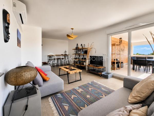 Il y a des biens qu'on visite et qu'on oublie. Et puis il y a celui-là.

Dernier étage. Duplex. Terrasse de 43 m² ouverte sur l'horizon. À cinq cents mètres de la plage. 
Sur le littoral héraultais, ce type de réunion ne se présente pas souvent, et quand ça arrive, ça ne reste pas longtemps sur le marché.

À la limite de Sérignan et de Valras-Plage, dans une résidence récente et soignée, cet appartement T4 de 113 m² habitables occupe les deux derniers niveaux. 
Dès qu'on pousse la porte, quelque chose se passe. Les volumes, d'abord. La lumière, ensuite. Et puis cet agencement qui semble avoir été pensé pour qu'on s'y sente bien dès le premier jour.

Au niveau inférieur s'articule une belle pièce de vie avec cuisine ouverte, salle à manger, deux chambres avec accès extérieur, salle de bain, WC séparé et cellier. 
Tout y est. Rien ne manque. On monte.

À l'étage, un salon indépendant, un vrai espace à soi: pour souffler, lire, regarder la nuit tomber. 
Il s'ouvre directement sur la terrasse principale, et c'est là que le bien bascule dans une autre catégorie. 

La suite parentale complète ce niveau : dressing, salle d'eau privative, WC : un cocon.

La terrasse de 43 m², en partie couverte, sans aucun vis-à-vis : ce n'est pas un extérieur, c'est une pièce supplémentaire à ciel ouvert: table pour dîner dehors, transat pour les matins calmes, apéros qui s'étirent jusqu'à la nuit, elle absorbe tout, accueille tout. 

Et depuis là-haut, la vue se déploie librement : un aperçu de mer, et par temps clair, le regard file jusqu'aux crêtes des Pyrénées Catalanes et au massif du Canigou. Ce genre de panorama, ça change une journée, ça change une vie.

Trois terrasses au total pour près de 62 m² d'extérieurs. 

Piscine dans la résidence. Place de stationnement privative. Local à vélos sécurisé. Commerces, médecins, restaurants et plage à pied. 

Rare. Le mot est souvent galvaudé dans l'immobilier. Pas ici.

La cerise sur le gâteau : il est vendu entièrement meublé et équipé.
Venez poser vos valises !