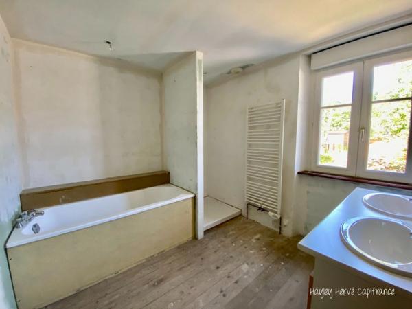 A vendre - Maison mitoyenne de 135 m² à finir à rénover avec jardin, garage et grenier, proche Saint Lo