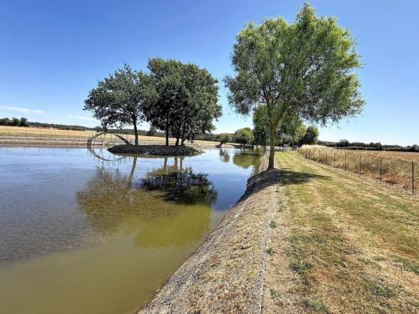 Terrain d'agrément avec un grand étang, une dépendance, une partie arboré.