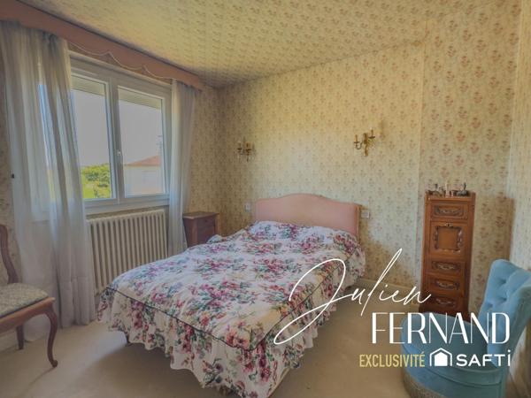 Maison à étage avec garage, véranda et jardin.