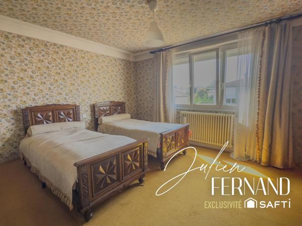 Maison à étage avec garage, véranda et jardin.