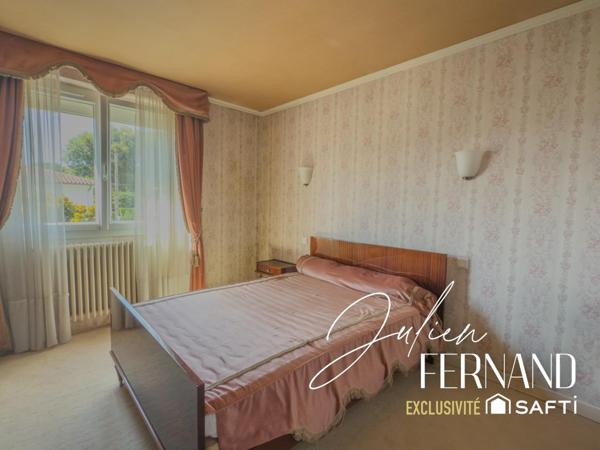 Maison à étage avec garage, véranda et jardin.