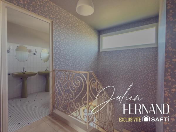 Maison à étage avec garage, véranda et jardin.