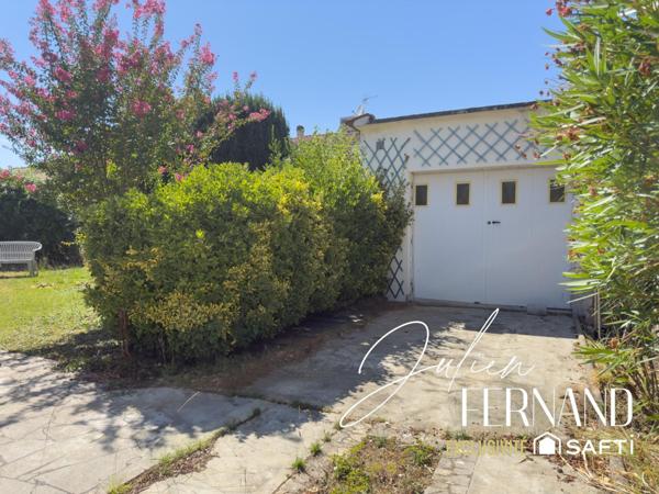 Maison à étage avec garage, véranda et jardin.