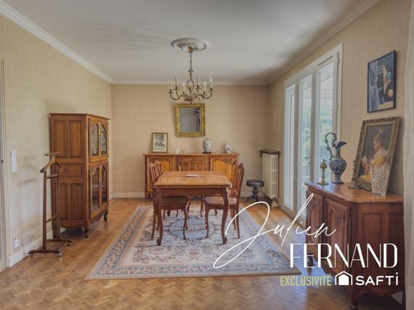 Maison à étage avec garage, véranda et jardin.