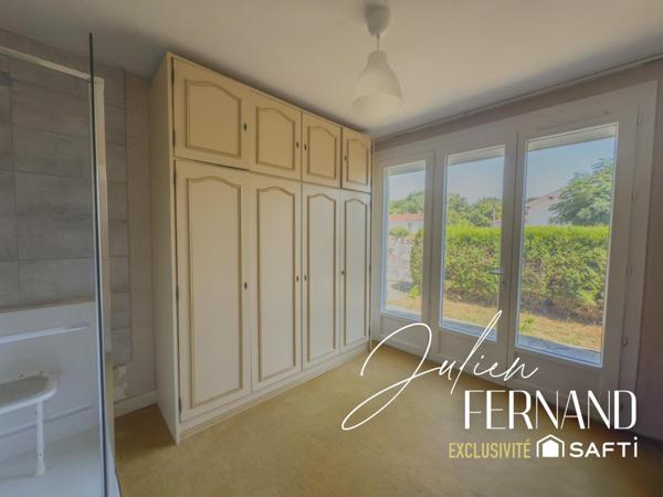 Maison à étage avec garage, véranda et jardin.