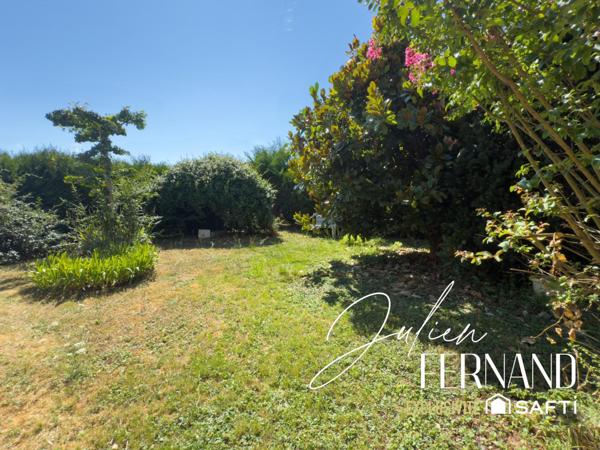 Maison à étage avec garage, véranda et jardin.