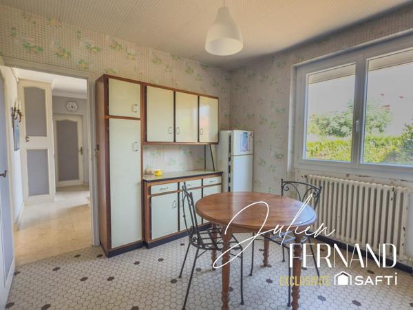 Maison à étage avec garage, véranda et jardin.