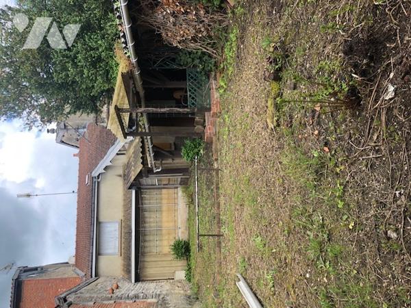 Une maison d'habitation avec terrain et dépendances avec un double garage non attenant et jardin.