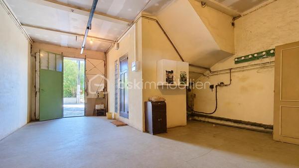 Cette maison d'environ 135 m² habitables offre de beaux volumes et un fort potentiel, idéale pour une famille ou pour un projet nécessitant des espaces de stockage ou d'activité.

L'habitation se compose d'une agréable pièce de vie prolongée par une grande véranda, d'une cuisine indépendante avec la possibilité de l'ouvrir sur le salon, de quatre chambres et d'une salle d'eau. Une petite terrasse permet également de profiter des beaux jours.

Le confort est assuré par un chauffage central et des menuiseries en double vitrage. Un premier garage accueille la chaufferie.

Son principal atout réside dans son exceptionnel garage/ hangar attenant d'environ 250 m², offrant de nombreuses possibilités : stationnement de plusieurs véhicules, atelier, activité artisanale, stockage ou encore aménagement selon vos besoins.

À l'extérieur, un espace de stationnement permet d'accueillir facilement plusieurs véhicules.

Quelques rafraîchissements sont à prévoir, laissant la possibilité de personnaliser cette maison selon vos envies.

Un bien rare par ses volumes et ses dépendances, qui conviendra aussi bien à une grande famille qu'à un artisan ou à toute personne recherchant un important espace de stockage ou de travail.