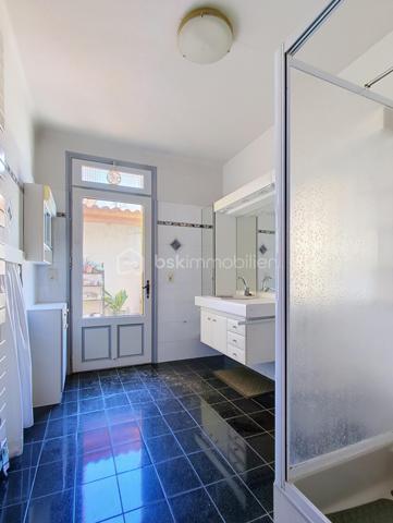 Cette maison d'environ 135 m² habitables offre de beaux volumes et un fort potentiel, idéale pour une famille ou pour un projet nécessitant des espaces de stockage ou d'activité.

L'habitation se compose d'une agréable pièce de vie prolongée par une grande véranda, d'une cuisine indépendante avec la possibilité de l'ouvrir sur le salon, de quatre chambres et d'une salle d'eau. Une petite terrasse permet également de profiter des beaux jours.

Le confort est assuré par un chauffage central et des menuiseries en double vitrage. Un premier garage accueille la chaufferie.

Son principal atout réside dans son exceptionnel garage/ hangar attenant d'environ 250 m², offrant de nombreuses possibilités : stationnement de plusieurs véhicules, atelier, activité artisanale, stockage ou encore aménagement selon vos besoins.

À l'extérieur, un espace de stationnement permet d'accueillir facilement plusieurs véhicules.

Quelques rafraîchissements sont à prévoir, laissant la possibilité de personnaliser cette maison selon vos envies.

Un bien rare par ses volumes et ses dépendances, qui conviendra aussi bien à une grande famille qu'à un artisan ou à toute personne recherchant un important espace de stockage ou de travail.