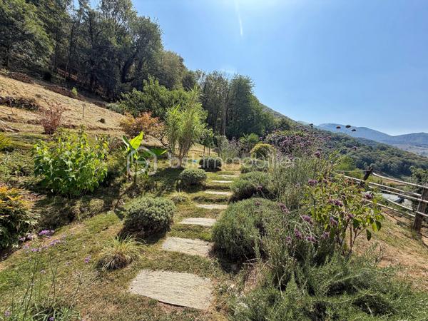 En exclusivité, à seulement 30 minutes de Bagnères-de-Bigorre, au cœur des Baronnies, découvrez cette propriété pleine de charme, nichée dans un environnement privilégié, au calme absolu, avec une vue exceptionnelle sur la nature environnante. Véritable havre de paix, cet ensemble immobilier séduit par son authenticité, son potentiel et son cadre de vie unique, idéal pour les amoureux de nature, de sérénité et de projets de vie inspirants.

La propriété se compose d’une maison principale chaleureuse et accueillante, ainsi que d’une seconde bâtisse offrant de multiples possibilités d’usage. 

La maison principale propose, au rez-de-chaussée, une grande cuisine équipée, pleine de charme et d’authenticité, où il fait bon partager les repas, un salon-séjour convivial, une salle d’eau rénovée avec goût ainsi qu’un WC séparé. À l’étage, un palier avec rangements dessert deux belles chambres lumineuses, elles aussi équipées de rangements, offrant confort et fonctionnalité au quotidien.

La seconde bâtisse complète harmonieusement l’ensemble avec un grand garage, un atelier avec rangements, une terrasse couverte aménagée en véritable espace de vie avec coin repas et ventilateur, ainsi qu’un studio cocooning disposant d’une kitchenette, d’une salle de douche et de toilettes sèches. Cet espace indépendant ouvre la voie à de nombreux projets : accueil d’amis ou de famille, location saisonnière, activité Airbnb, espace de travail ou atelier créatif.

À l’extérieur, le terrain arboré de 8 300 m² constitue un atout majeur. Déjà aménagé avec soin, il accueille une serre, des potagers, des vergers, un poulailler ainsi qu’un petit chalet avec terrasse, dans une atmosphère naturelle et inspirante. Ici, tout invite à imaginer un mode de vie plus autonome, plus doux, plus proche de la nature. Le bien offre également un joli potentiel de développement, notamment pour un projet d’hébergement touristique avec plusieurs petits chalets, ou pour une vie tournée vers l’autosuffisance.

Le confort est assuré par un chauffage électrique complété par un poêle à bois, pour une ambiance chaleureuse en toute saison. Ce bien rare séduira autant les acquéreurs en quête d’une résidence principale de caractère que les porteurs de projet recherchant un lieu à fort potentiel dans un cadre préservé.

Un bien atypique, authentique et inspirant, à découvrir sans tarder.