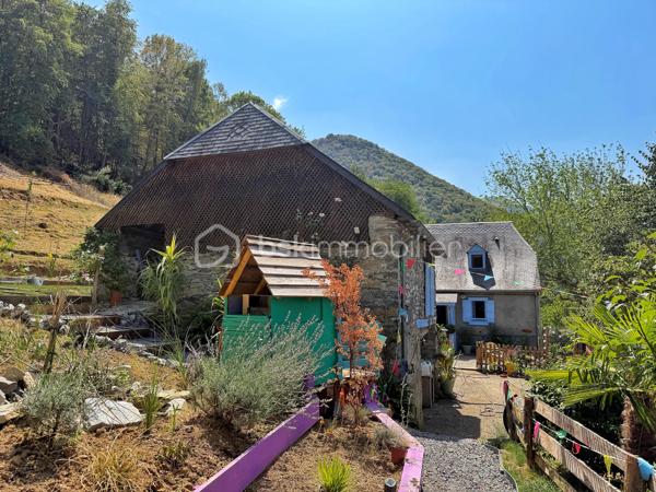 En exclusivité, à seulement 30 minutes de Bagnères-de-Bigorre, au cœur des Baronnies, découvrez cette propriété pleine de charme, nichée dans un environnement privilégié, au calme absolu, avec une vue exceptionnelle sur la nature environnante. Véritable havre de paix, cet ensemble immobilier séduit par son authenticité, son potentiel et son cadre de vie unique, idéal pour les amoureux de nature, de sérénité et de projets de vie inspirants.

La propriété se compose d’une maison principale chaleureuse et accueillante, ainsi que d’une seconde bâtisse offrant de multiples possibilités d’usage. 

La maison principale propose, au rez-de-chaussée, une grande cuisine équipée, pleine de charme et d’authenticité, où il fait bon partager les repas, un salon-séjour convivial, une salle d’eau rénovée avec goût ainsi qu’un WC séparé. À l’étage, un palier avec rangements dessert deux belles chambres lumineuses, elles aussi équipées de rangements, offrant confort et fonctionnalité au quotidien.

La seconde bâtisse complète harmonieusement l’ensemble avec un grand garage, un atelier avec rangements, une terrasse couverte aménagée en véritable espace de vie avec coin repas et ventilateur, ainsi qu’un studio cocooning disposant d’une kitchenette, d’une salle de douche et de toilettes sèches. Cet espace indépendant ouvre la voie à de nombreux projets : accueil d’amis ou de famille, location saisonnière, activité Airbnb, espace de travail ou atelier créatif.

À l’extérieur, le terrain arboré de 8 300 m² constitue un atout majeur. Déjà aménagé avec soin, il accueille une serre, des potagers, des vergers, un poulailler ainsi qu’un petit chalet avec terrasse, dans une atmosphère naturelle et inspirante. Ici, tout invite à imaginer un mode de vie plus autonome, plus doux, plus proche de la nature. Le bien offre également un joli potentiel de développement, notamment pour un projet d’hébergement touristique avec plusieurs petits chalets, ou pour une vie tournée vers l’autosuffisance.

Le confort est assuré par un chauffage électrique complété par un poêle à bois, pour une ambiance chaleureuse en toute saison. Ce bien rare séduira autant les acquéreurs en quête d’une résidence principale de caractère que les porteurs de projet recherchant un lieu à fort potentiel dans un cadre préservé.

Un bien atypique, authentique et inspirant, à découvrir sans tarder.