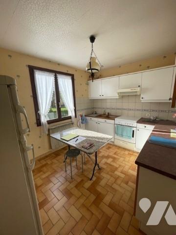 Pavillon des années 1990 sur sous-sol avec terrain autour.