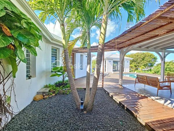 Coup de coeur assuré pour cette villa contemporaine offrant de beaux volumes d'une surface habitable de 119 m2 (surface utile 160 m2)
édifiée de plain-pied sur une parcelle de 1543 m2.
A seulement 5 minutes des commodités du centre-ville et de la plage des Raisins Clairs, au calme elle bénéficie d'un environnement idéal.
De construction atypique, elle se compose de 3 modules
- le premier est un espace pièce à vivre de 40 m2 avec son grand salon et sa cuisine ouverte équipée moderne , un toilette invité, un cellier
extérieur.
- Empruntez le patio et vous accédez au second module offrant deux grandes suites parentales climatisées avec douche à l'italienne, dressing
et toilettes.
- Enfin, le troisième espace bénéficiant d'une vue directe avec ses baies vitrées sur la piscine est une troisième suite parentale climatisée
avec son dressing, sa salle d'eau douche à l'italienne et toilettes.
Vous profiterez également d'une grande terrasse et sa piscine au sel de dimension 4x4 (achevée il y a un an) avec son liner pierres de Bali.
La villa sera cédée avec son mobilier vous n'avez plus qu'à poser vos valises!
Ses équipements : citerne tampon 3300 litres , fibre optique, carport pouvant abriter 2 véhicules et assainissement individuel avec conformité.
Atout supplémentaire: la bonne implantation de la villa sur la parcelle laisse place à une bande de terrain restante laissant un potentiel de
construction additionnel (située en zone u4 du PLU) comme des bungalows ...
Etiquette énergétique: classe B
Vous l'avez compris cette villa est un petit bijou avec encore un potentiel restant, alors n'hésitez pas à me contacter pour de plus amples
informations, accéder au reportage photos complet ou à la vidéo!
Pour le réseau BSK Immobilier : Delphine MIRANDA (EI)
Honoraires charge vendeur