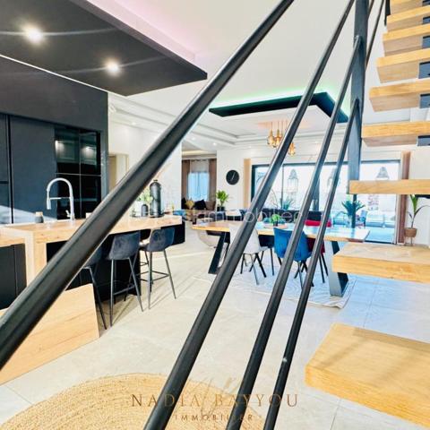 Dans un environnement privilégié, découvrez cette somptueuse villa contemporaine aux prestations haut de gamme, où confort, raffinement et modernité s’harmonisent parfaitement.

Dès l’entrée, vous serez séduits par les beaux volumes, la luminosité naturelle et les finitions élégantes. L’espace de vie, chaleureux et raffiné, accueille une superbe cuisine moderne ouverte sur un vaste séjour baigné de lumière, sublimé par des matériaux de qualité et un magnifique escalier design.

La villa offre quatre belles chambres, dont une splendide suite parentale à l’étage avec terrasse privative, salle d’eau et vue dégagée sur la nature environnante, créant un véritable cocon de sérénité.

Au rez-de-chaussée, l’espace nuit bénéficie également d’une superbe salle de bain contemporaine avec baignoire îlot, douche à l’italienne et double vasque, pensée comme un véritable espace bien-être.

À l’extérieur, chaque espace a été aménagé avec soin pour profiter pleinement de chaque instant : jardin paysagé aux inspirations méditerranéennes, agréable terrasse couverte, piscine avec espace détente et environnement paisible avec vue dégagée sur la nature.

✨ Une magnifique maison familiale alliant élégance, confort et qualité de vie dans un cadre rare et recherché.

📞 Je reste à votre disposition pour organiser une visite et vous faire découvrir ce bien unique.