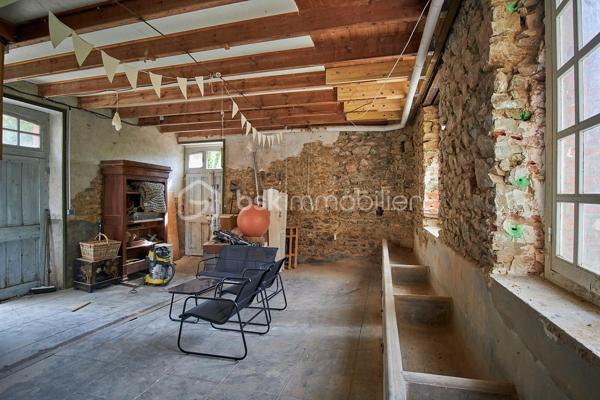 Nichée dans un cadre verdoyant et particulièrement paisible, cette maison individuelle de caractère datant du début des années 1900 séduira les amateurs de nature et d'authenticité. Située en bordure du célèbre sentier côtier GR34, elle permet de rejoindre facilement la plage du Palus à pied. Implantée sur un terrain arboré de plus de 1 600 m², la propriété profite de plusieurs espaces extérieurs offrant de nombreuses possibilités d'aménagement : espaces de détente, jardin d'agrément, potager, aire de jeux ou encore verger. Un véritable écrin de verdure pour profiter pleinement du calme environnant.

Édifiée sur plusieurs niveaux, la maison offre de beaux volumes et un fort potentiel d'évolution. Elle se compose :
- Au rez-de-chaussée :
        - Une entrée avec escalier desservant l'étage ;
        - Une buanderie/laverie avec accès direct à une terrasse exposée Est.
- Au rez-de-chaussée surélevé :
        - Une cuisine indépendante d'environ 15 m² ;
        - Une salle à manger d'environ 20 m² ouvrant sur un balcon exposé Sud et permettant l'accès au jardin ;
        - Un grand salon de plus de 40 m² ;
        - Un WC indépendant avec lave-mains.

- À l'étage :
        - Un palier ;
        - Une salle d'eau avec WC ;
        - Une chambre de 13 m² avec cheminée et balcon exposé Sud ;
        - Une seconde chambre de 18 m² avec salle d'eau privative, un petit dressing et balcon exposé Ouest.

- En rez-de-jardin :
Plus de 80 m² d'espaces aménageables répartis en quatre volumes dont un espace technique et bénéficiant de plusieurs accès sur l'extérieur. Ces volumes offrent un potentiel remarquable pour créer des pièces de vie supplémentaires, un espace de réception, un atelier ou encore une activité indépendante.

Un garage indépendant complète l'ensemble.

Si une rénovation intérieure reste à envisager, notamment au niveau du rez-de-jardin, de nombreux travaux structurants ont d'ores et déjà été réalisés : réfection complète de la toiture, installation d'une pompe à chaleur Viessmann, d'un ballon thermodynamique, d'un poêle à bois, mise en place d'une VMC, isolation des combles par insufflation, rénovation de l'installation électrique et assainissement individuel avec filtre compact coco aux normes.

Une propriété pleine de charme, idéale pour les amoureux de la nature et du littoral, à la recherche d'un bien de caractère à personnaliser selon leurs envies.