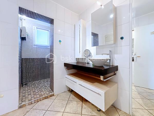 Située au 11 rue Léo Lagrange à Échirolles, cette maison individuelle construite en 1958 , d'une surface au sol de 160 m² est implantée sur une parcelle de 450 m² environ. Soigneusement entretenue au fil des années, elle bénéficie de nombreux travaux récents : ravalement de façade réalisé en 2026, chaudière remplacée en 2025 et toiture nettoyée et démoussée en 2023, offrant ainsi un bien parfaitement entretenu.

Le rez-de-chaussée (74 m²) se compose d'un garage avec porte motorisée (24 m²), d'une cuisine d'été pouvant faire office de buanderie, d'une salle d'eau, de WC indépendants, d'une cave ainsi que de plusieurs espaces de rangement. Une pièce supplémentaire offre un véritable potentiel d'aménagement, idéale pour la création d'un studio indépendant, d'un espace professionnel ou d'un bureau pour une activité libérale.

Le premier étage, d'environ 63m² climatisés, accueille un espace de vie chaleureux comprenant une cuisine semi-ouverte entièrement équipée, un séjour lumineux avec accès à un balcon exposé Ouest, deux chambres, dont une avec dressing, une salle d'eau moderne avec douche à l'italienne, sèche-serviettes et rangements, ainsi que des WC séparés. Les menuiseries PVC en double vitrage et les volets roulants électriques assurent un confort optimal au quotidien.

Les combles aménagés offrent une vaste pièce mansardée, parfaite pour créer une chambre supplémentaire, un bureau, une salle de jeux ou un espace détente. Des rangements intégrés et des fenêtres de toit type Velux viennent compléter cet espace.

Les atouts de cette maison :
Maison individuelle sur une parcelle de 450 m²
Façade, chaudière et toiture récemment rénovées
Climatisation
Menuiseries PVC double vitrage
Volets roulants électriques
Garage avec porte motorisée
Combles aménagés
Fort potentiel d'aménagement avec possibilité de créer un studio indépendant ou un espace professionnel