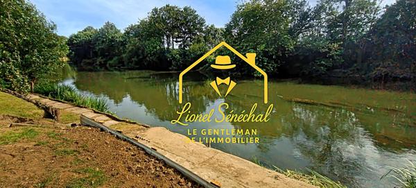 Terrain de loisirs de plus de 1 200 m2 avec un préau sur une dalle en dur, un abri de jardin et un accès direct à la rivière