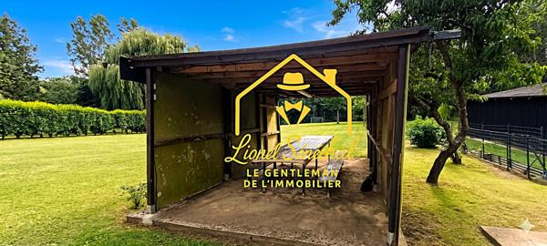 Terrain de loisirs de plus de 1 200 m2 avec un préau sur une dalle en dur, un abri de jardin et un accès direct à la rivière