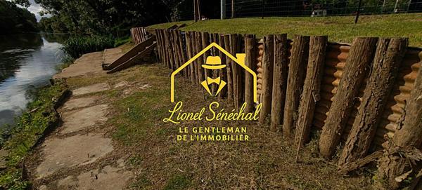 Terrain de loisirs de plus de 1 200 m2 avec un préau sur une dalle en dur, un abri de jardin et un accès direct à la rivière
