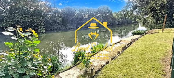 Terrain de loisirs de plus de 1 200 m2 avec un préau sur une dalle en dur, un abri de jardin et un accès direct à la rivière