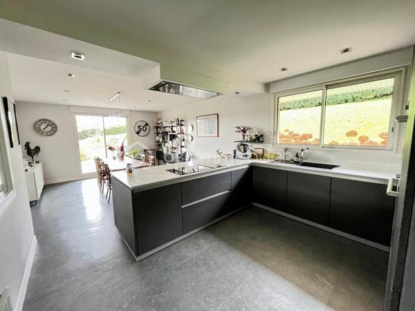 Aux portes de LANDERNEAU et de toutes ses commodités, belle maison d’architecte entourée d’un beau jardin de 4000 m2.

REZ-DE-CHAUSSEE :
ESPACE DE VIE d’environ 80 m² comprenant une cuisine ouverte sur la salle à manger ainsi qu’un séjour lumineux doté de larges baies vitrées exposées plein sud, donnant accès à une agréable terrasse.
Hall d’entrée
WC
L’ESPACE NUIT offre une lingerie, une salle d’eau, deux chambres confortables ainsi qu’une suite parentale comprenant une salle de bain avec douche et baignoire. Un WC séparé vient compléter cet espace.

A L’ETAGE : mezzanine/salon de 32m² sous large verrière, deux chambres, une salle d’eau avec wc et une salle de 65 m² pouvant être aménagée en salle de jeux, salle de sport ou selon vos envies.

SOUS-SOL COMPLET comprenant un garage de 60 m², une buanderie, une cave à vin et de nombreux espaces de rangement.