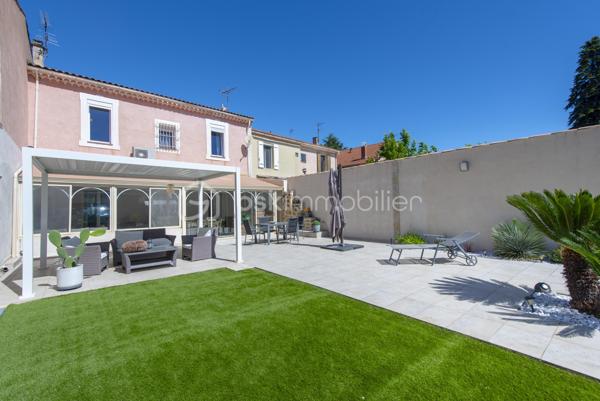 Belle maison de caractère située en centre-ville de Miramas, dans les Bouches-du-Rhône. Avec ses 150 m² habitables répartis sur deux niveaux, elle offre de beaux volumes et un cadre de vie agréable, idéal pour une famille.

Au rez-de-chaussée, vous découvrez une entrée, un vaste salon, une salle à manger, une cuisine indépendante, une buanderie et un WC. Les hauteurs sous plafond généreuses — plus de 3 mètres — apportent une vraie sensation d'espace et de luminosité. La configuration du rez-de-chaussée offre également la possibilité de créer une chambre supplémentaire sans aucun travaux, un vrai plus pour les familles.

À l'étage, la maison propose 4 chambres avec leurs placards, une salle d'eau et un palier spacieux.

La maison bénéficie également d'annexes très appréciables : une véranda de 34 m², une buanderie, deux caves en sous-sol.

Côté équipements, le bien est chauffé et climatisé par une pompe à chaleur air/air, et dispose de panneaux photovoltaïques. Les menuiseries sont en double vitrage.