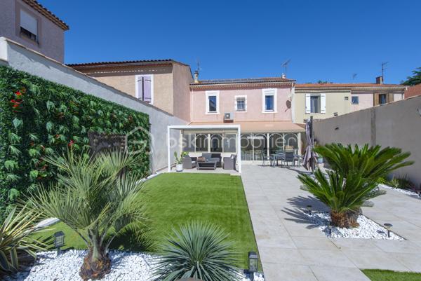 Belle maison de caractère située en centre-ville de Miramas, dans les Bouches-du-Rhône. Avec ses 150 m² habitables répartis sur deux niveaux, elle offre de beaux volumes et un cadre de vie agréable, idéal pour une famille.

Au rez-de-chaussée, vous découvrez une entrée, un vaste salon, une salle à manger, une cuisine indépendante, une buanderie et un WC. Les hauteurs sous plafond généreuses — plus de 3 mètres — apportent une vraie sensation d'espace et de luminosité. La configuration du rez-de-chaussée offre également la possibilité de créer une chambre supplémentaire sans aucun travaux, un vrai plus pour les familles.

À l'étage, la maison propose 4 chambres avec leurs placards, une salle d'eau et un palier spacieux.

La maison bénéficie également d'annexes très appréciables : une véranda de 34 m², une buanderie, deux caves en sous-sol.

Côté équipements, le bien est chauffé et climatisé par une pompe à chaleur air/air, et dispose de panneaux photovoltaïques. Les menuiseries sont en double vitrage.