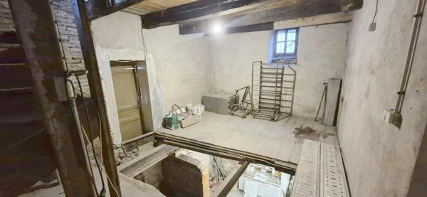 Maison en pierre à rénover avec local professionnel restauré en activité.