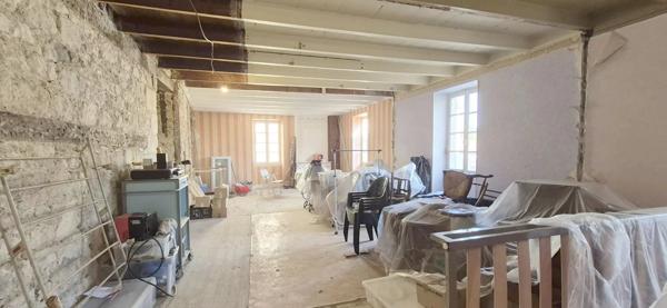Maison en pierre à rénover avec local professionnel restauré en activité.