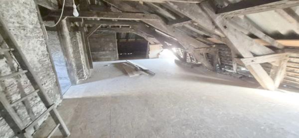 Maison en pierre à rénover avec local professionnel restauré en activité.