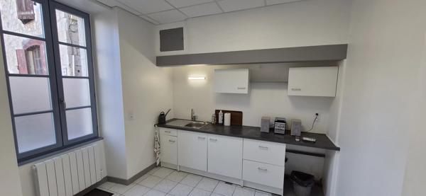 Maison en pierre à rénover avec local professionnel restauré en activité.