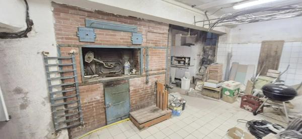 Maison en pierre à rénover avec local professionnel restauré en activité.