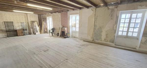 Maison en pierre à rénover avec local professionnel restauré en activité.