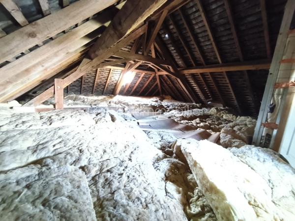 Je vous propose de découvrir cette charmante maison de 1907, pleine de caractère et très bien entretenue. Les matériaux nobles d'époque et de qualité utilisés pour la construction de ce bien vous inspireront confiance et sérénité. Véritable opportunité à saisir, cette maison idéalement située bénéficie d’un cadre paisible à proximité du centre bourg avec son école et son arrêt de bus. Les deux places de parking avec la possibilité d'installer un auvent pour abriter les véhicules sont un véritable atout pour la vie du quotidien.

Dès l'entrée, vous serez séduit par un intérieur spacieux et chaleureux. La belle hauteur sous plafond avec ses poutres apparentes et les tomettes au sol vous renverront tout le cachet de cette maison ancienne.

La visite débutera par la grande cuisine aménagée et tout équipée de 21m² alliant fonctionnalité et praticité. Un vaste salon prolonge l’espace de vie de ce rez-de-chaussée de 40m²convivial et lumineux. Une première salle d'eau se trouvant en contre-bas, accessible par quelques marches, équipée d'une douche, d'un lavabo et d'un WC saura vous ravir par son agencement et sa clarté.

Au premier étage, un agréable couloir distribuant deux chambres de 17m² et 10m² offre également une seconde salle d'eau comprenant un lavabo et un WC. La possibilité d'installer une douche permet d'envisager plus de confort à cette pièce située au cœur de cet étage.
Au fond de ce couloir, des escaliers vous mèneront à un grenier de 40m² au sol, mettant en lumière une charpente en parfait état. Ce dernier étage est entièrement aménageable, ce qui laisse entrevoir un beau potentiel d'extension de superficie habitable non négligeable.

L'extérieur d'environ 50m² très bien entretenu avec sa terrasse de 12m² et son joli jardin engazonné et arboré parachèvera cette visite. Vous pourrez vous projeter à vivre des moments de détente auprès du puits, pratique pour l'irrigation de vos plantes ou un éventuel petit potager. Un préau de 10m², pratique pour abriter le nécessaire, trouve parfaitement sa place dans cet espace privilégié.

Une opportunité rare, sans travaux immédiats à prévoir, alliant charme et potentiel. À saisir sans hésiter !