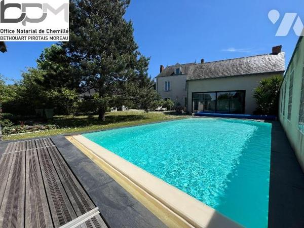 A Mûrs-Érigné, cette propriété de caractère et de charme, clos de murs, offre un cadre de vie e...