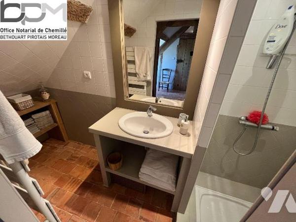 A Mûrs-Érigné, cette propriété de caractère et de charme, clos de murs, offre un cadre de vie e...