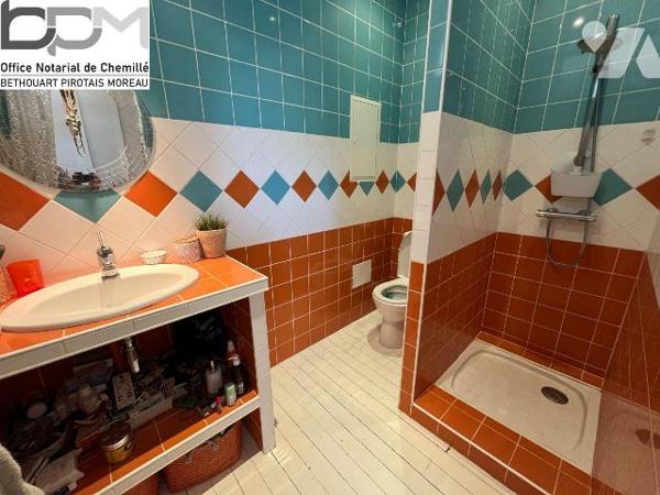 A Mûrs-Érigné, cette propriété de caractère et de charme, clos de murs, offre un cadre de vie e...