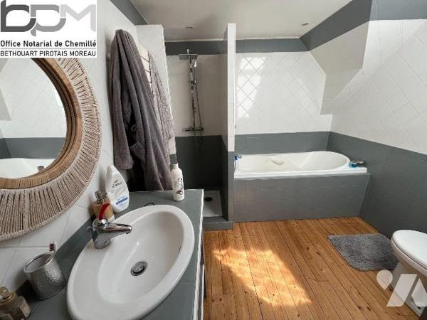 A Mûrs-Érigné, cette propriété de caractère et de charme, clos de murs, offre un cadre de vie e...